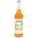 A bottle of Monin mango fruit syrup with a label.