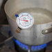 A Taylor candy and deep fry thermometer on a metal pot.