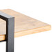 A Cal-Mil Madera rustic pine 3-shelf metal frame riser with a black frame on a wood table.