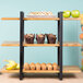 A Cal-Mil Madera rustic pine 3-shelf metal frame riser with food and muffins on it.