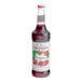 A white labeled Monin Premium Pomegranate syrup bottle.