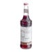 A bottle of Monin pomegranate syrup with a white label.