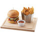 A Cal-Mil stainless steel french fry holder with fries and sauce on a wooden board.
