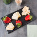 A Cal-Mil rectangular melamine tray with cheese, strawberries, and crackers on a table.