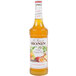 A bottle of Monin Premium White Sangria Mix with an orange label.
