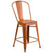 An orange metal restaurant bar stool with a back.