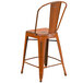 A Flash Furniture distressed orange metal restaurant bar stool with a vertical slat backrest.