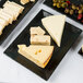 A Cal-Mil faux slate melamine platter with cheese and olives.