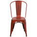 A Flash Furniture distressed red metal chair with a slat seat and drain hole.