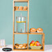 A Cal-Mil Madera rustic pine display stand with food on it.