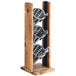 A wooden Cal-Mil Madera vertical holder with three metal containers holding utensils.