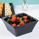 A Cal-Mil faux slate square bowl filled with fruit and pastries.
