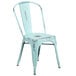 A distressed blue metal chair with a vertical slat back and drain hole seat.