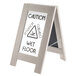 A Cal-Mil composite wet floor sign on a stand with caution on both sides.