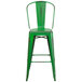 A Flash Furniture green metal bar stool with a back.