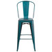A blue metal bar stool with a vertical slat backrest.