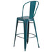 A teal metal bar stool with a vertical slat back.