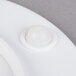A white Elite Global Solutions melamine plate with a white round object in the center.