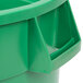 A green plastic Continental 3200GN Huskee trash can with a handle.