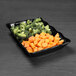 A black Elite Global Solutions scalloped melamine tray with broccoli and carrots.