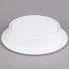 A white Elite Global Solutions round melamine pedestal plate on a gray surface.