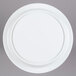 An Elite Global Solutions white melamine pedestal plate on a gray surface.
