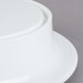 An Elite Global Solutions white melamine pedestal with a white bowl with a lid on top.