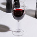 A Spiegelau red wine glass filled with red wine on a table.