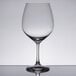 A close-up of a clear Spiegelau Vino Grande wine glass on a reflective surface.