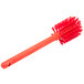 A red Carlisle Sparta Spectrum bottle cleaning brush with a handle.