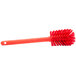 A close-up of a red Carlisle Sparta Spectrum bottle cleaning brush with a handle.
