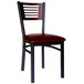 A BFM Seating black metal side chair with mahogany wood back and burgundy vinyl seat.