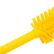 A close-up of a Carlisle yellow bottle and carafe cleaning brush with bristles.