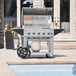 A Crown Verity mobile outdoor grill on a cart with a gas cylinder.