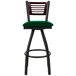 A BFM Seating restaurant bar stool with a green vinyl swivel seat and black metal legs.