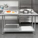 A Steelton stainless steel work table with an undershelf holding food.