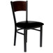 A black metal BFM Seating side chair with a black vinyl seat and walnut finish wooden back.