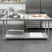 A Steelton stainless steel work table with an undershelf in a kitchen with food on it.