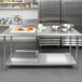 A Steelton stainless steel work table with an undershelf and a bowl of food on it.
