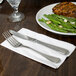 A fork and knife on a white Response Eco-Friendly dinner napkin.