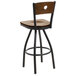 A BFM Seating black metal bar height chair with a swivel walnut wooden seat and backrest.