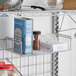 A Metro SmartWall G3 chrome grid shelf with side ledges holding food items.