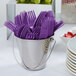 A bucket of amethyst purple plastic forks.
