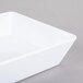 An American Metalcraft white square shallow melamine bowl on a gray surface.