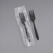 Two Choice medium weight black plastic forks individually wrapped in plastic.