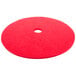 A red Scrubble buffing pad for a floor machine with a hole in the middle.