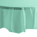 A table covered in a fresh mint green Creative Converting OctyRound plastic table cover.