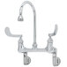A T&S chrome wall mounted surgical sink faucet with two wrist action handles and a rigid gooseneneck.