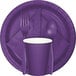 A purple Creative Converting dinner napkin with silverware on a purple plate.
