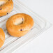 A clear Cambro market tray with a bagel topped with blueberries on it.